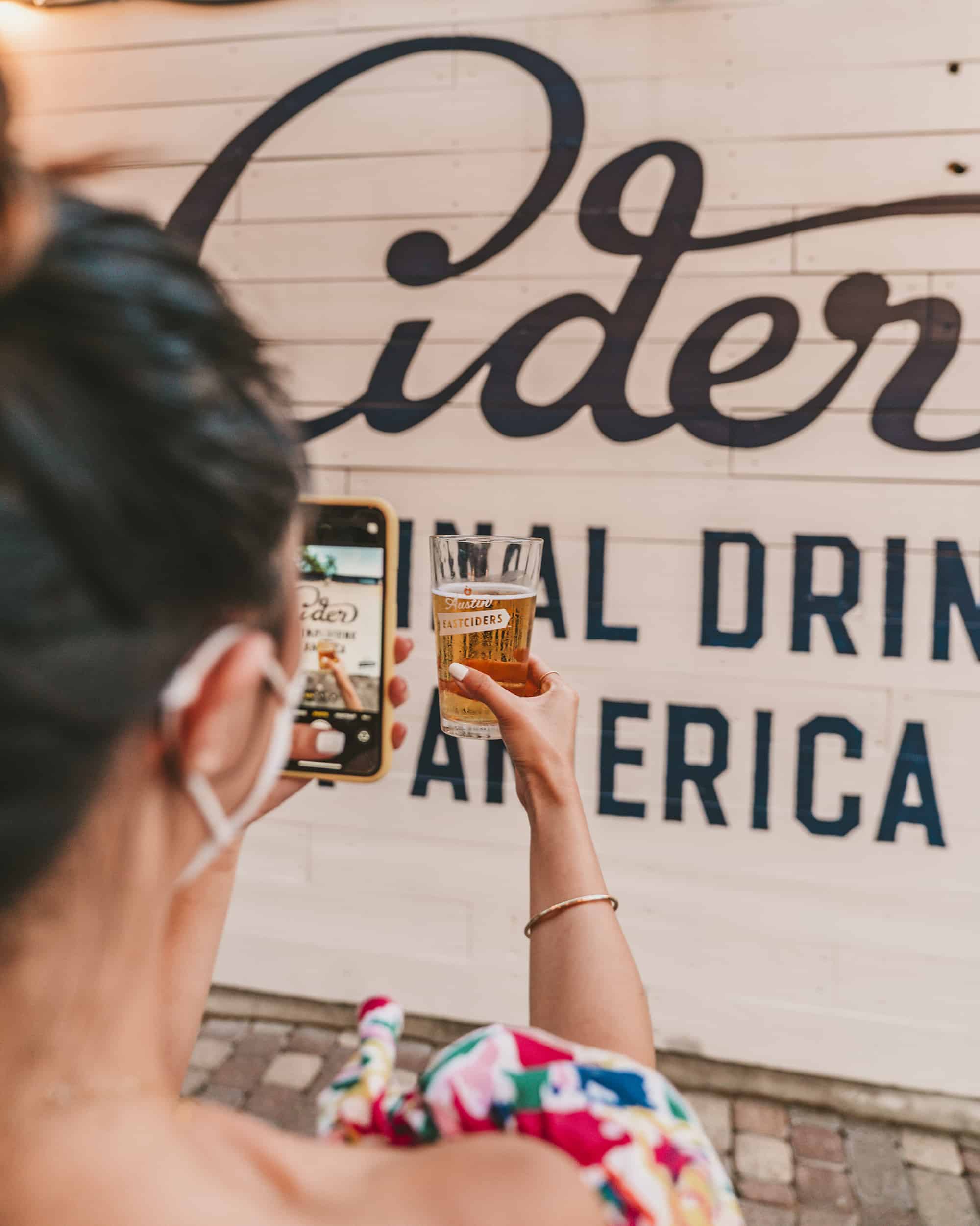 Girl taking a photo of her drink with iPhone